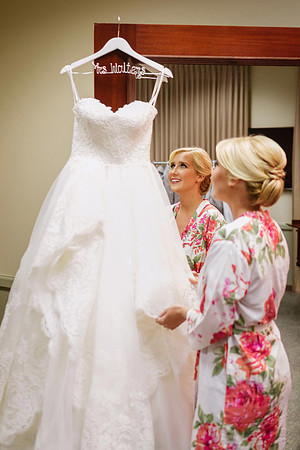 Bride-Looking-At-Dress-Hanging-Getting-Ready